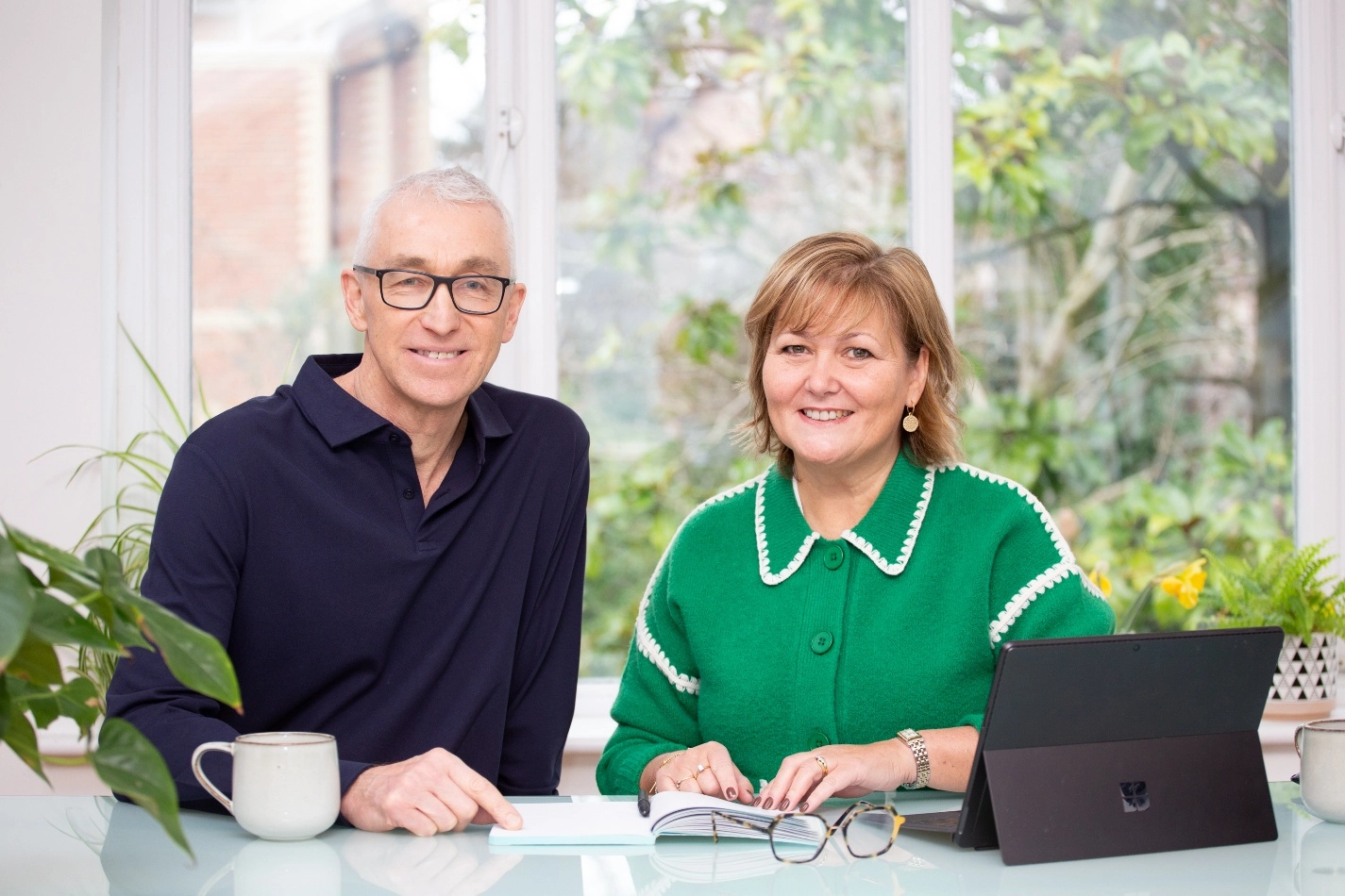Smiling couple sitting at a table indoors.